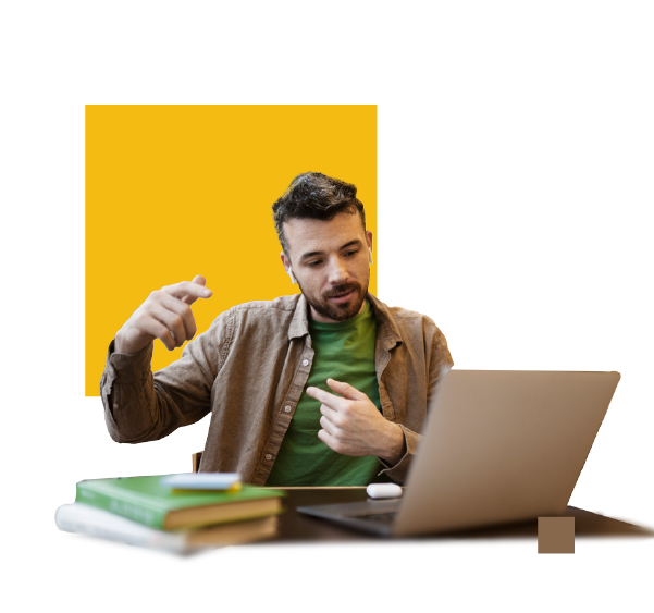 A young man with short dark hair and a beard is sitting at a desk, engaged in a video call on his laptop. His hands are gesturing expressively as he speaks, and he has an attentive expression. On the desk, there are two stacked books, a smartphone, and a pair of white earbuds. The background features a modern graphic design with a yellow square behind him and a small brown square near the laptop.