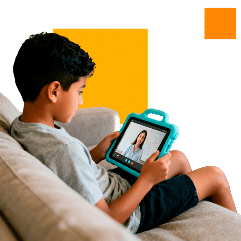 Boy sitting on a couch using a tablet to attend a 1-on-1 session on an online tutoring platform with a female teacher.